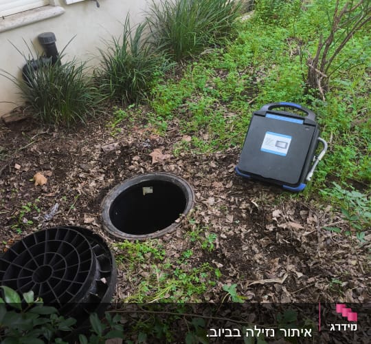 מכשיר ליד פתח ביוב בגינה